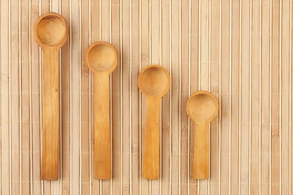 Wooden spoon  on a bamboo mat — Stock Photo, Image