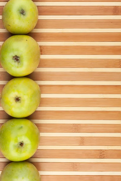 Green apples lie on  bamboo mat — Stock Photo, Image