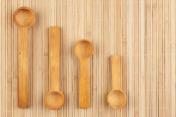 Wooden spoon  on a bamboo mat — Stock Photo, Image