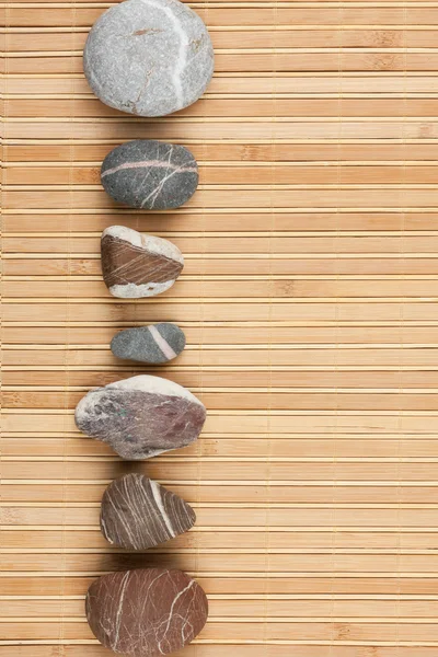 A number striped stones on a bamboo mat — Stock Photo, Image