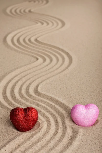 Dwa serca koncepcyjne w piasku — Zdjęcie stockowe