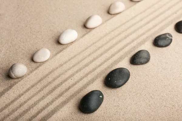 Stripe of white and black stones lying on the sand — Stock Photo, Image