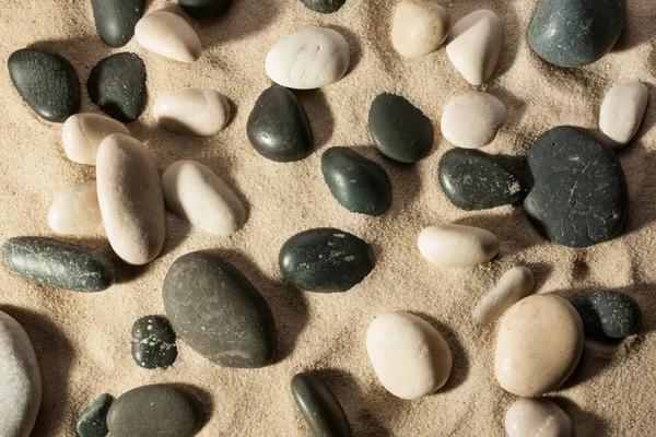 石头埋在沙子在阳光下的特写 — 图库照片