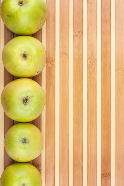 Green  apples lie on  bamboo mat — Stock Photo, Image