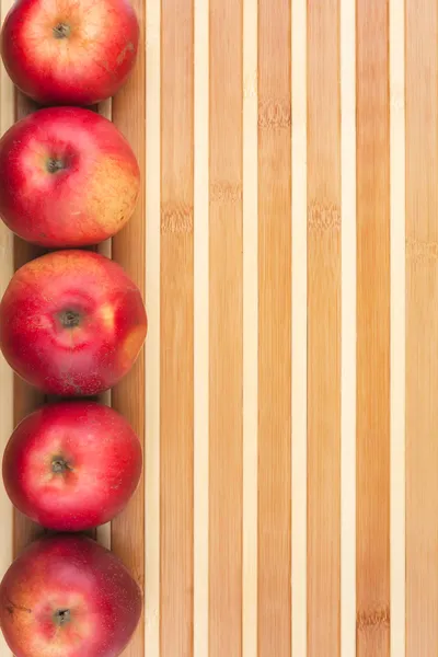 Red  apples lie on  bamboo mat — Stock Photo, Image