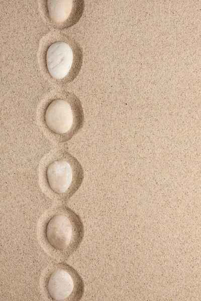 Beyaz taşlar kumun üzerinde yatan bir satýr — Stok fotoğraf