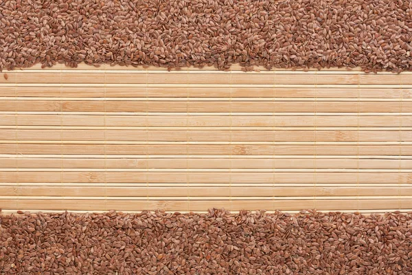 Semillas de lino en una estera de bambú —  Fotos de Stock