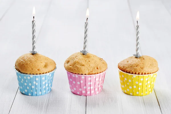 Drie muffins met kaarsen — Stockfoto