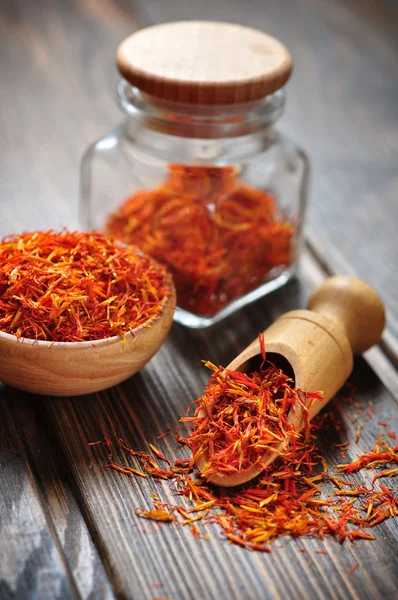 Saffron in wooden bowl on wooden background — Stock Photo, Image