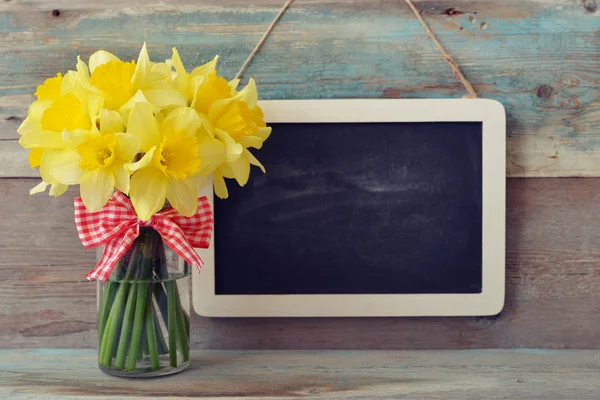 Inramade blackboard med påskliljor — Stockfoto