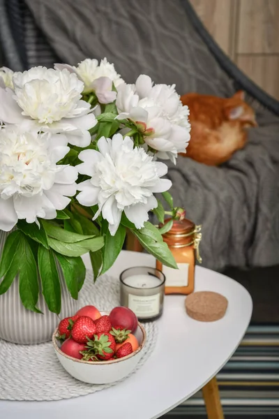 อดอกไม ดอกพ โอน ขาวบนโต ะกาแฟพร อมสตรอเบอร สดและเท ยนในบ — ภาพถ่ายสต็อก