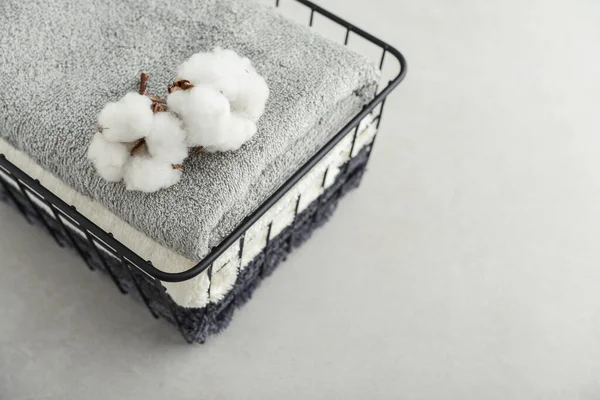 Stos Ręczników Kąpielowych Kwiatami Bawełny Czarnym Metalowym Koszu Jasnym Betonowym — Zdjęcie stockowe