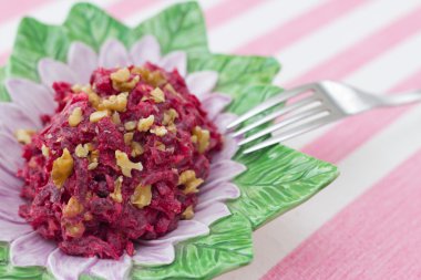 sarılı pembe bir arka plan üzerinde kırmızı pancar ve ceviz salata
