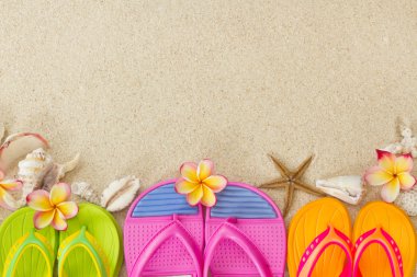 Flip Flops in the sand with shells and frangipani flowers. Summe clipart