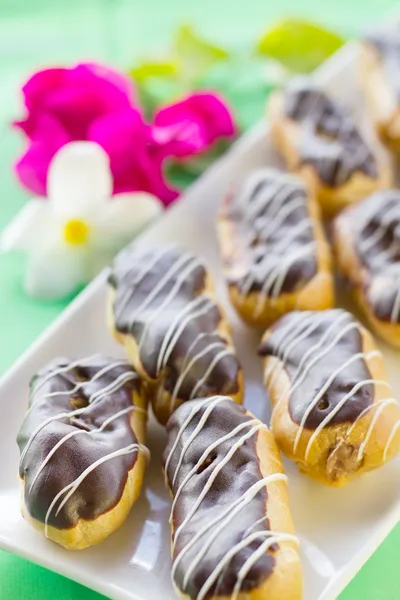 Chocolate Eclairs en plato blanco cuadrado — Foto de Stock