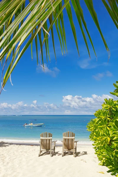 Strandstoelen op witte zandstrand met blauwe hemelachtergrond — Stockfoto