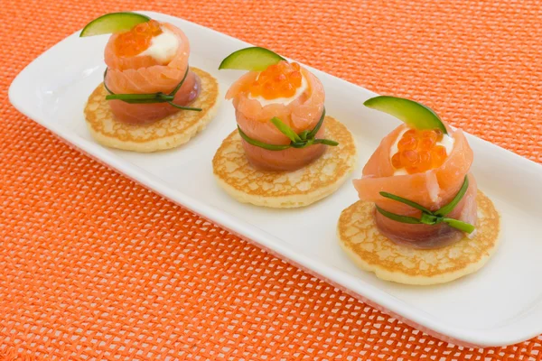 Röd lax rulla ost, kaviar, gurka på Blinier — Stockfoto