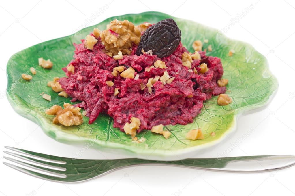 Beetroot salad with walnuts on green plate