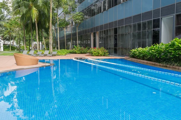 Large blue swimming pool with swimming path and cozy chair on si — Stock Photo, Image