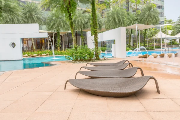 Four nice Leaf-like resting chairs by beautiful swimming pool si — Stock Photo, Image