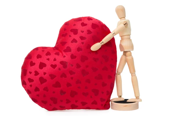 Wooden mannequin with a gigantic soft red heart — Stock Photo, Image