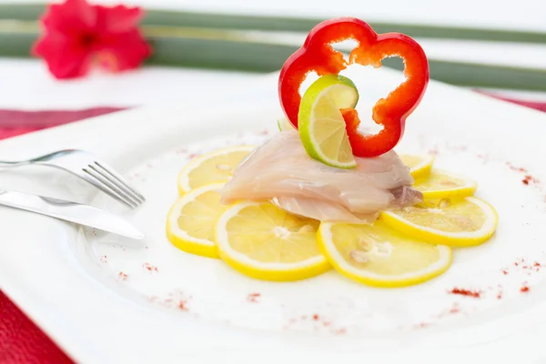 Carpaccio de pescado en rodajas de limón decoradas con rodajas de pimiento — Foto de Stock