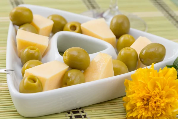 Green olives and cheese appetizer in a white dish — Stock Photo, Image