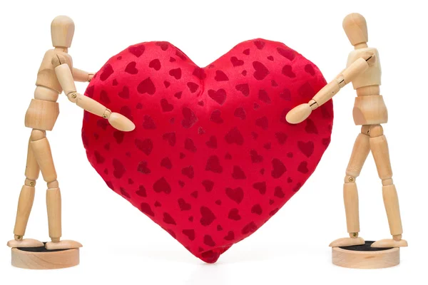 Two wooden dolls, mannequins holding huge red heart over a white — Stock Photo, Image