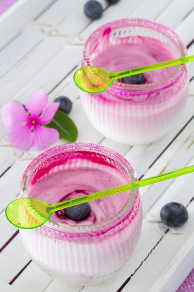 Two glasses of yogurt dessert on white tray, with blueberries an — Stock Photo, Image