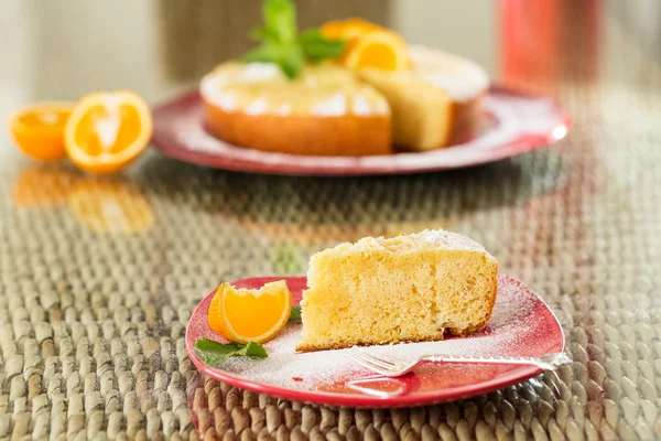 Rebanada de pastel de naranja recién cocinado en plato rojo — Foto de Stock