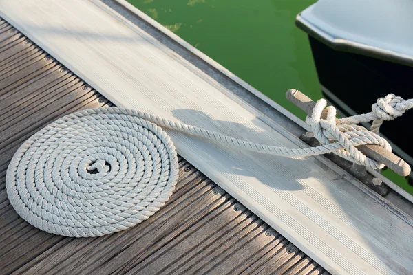 White rope coiled on a wooden dock — Stock Photo, Image