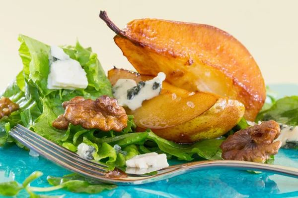 Ensalada con peras caramelizadas, nueces y queso, en plato azul — Foto de Stock
