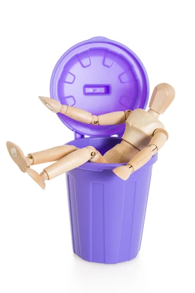 Wooden mannequin doll sitting in purple dustbin can, isolated — Stock Photo, Image