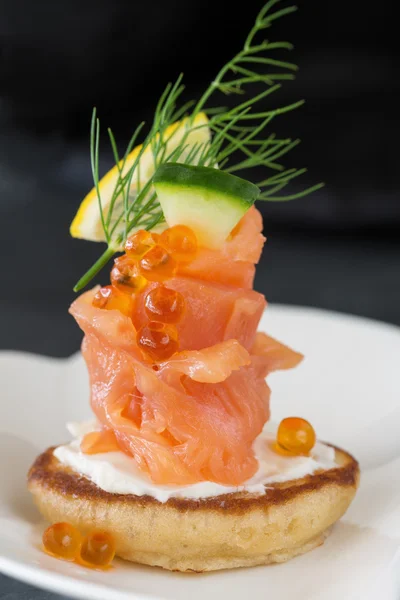 Één blini voorgerecht met gerookte zalm, kaviaar en zure room — Stockfoto