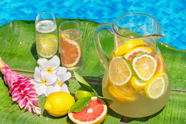 Jarra de limonada helada casera en el borde de la piscina — Foto de Stock