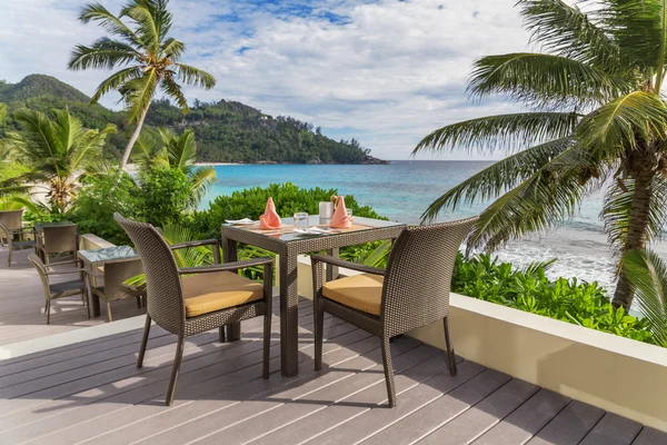 Table with chairs on decking, by the sea — Stock Photo, Image