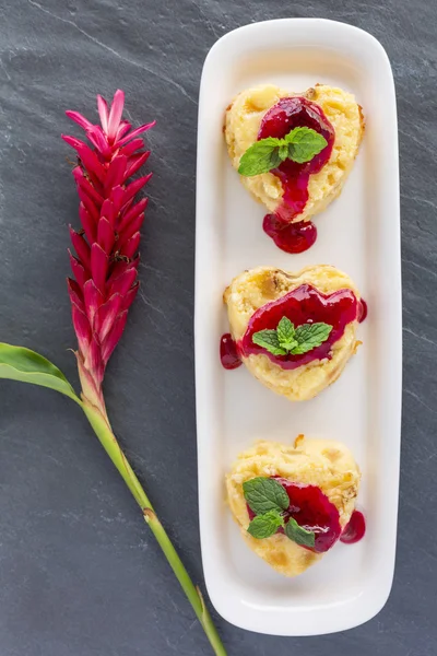 Hüttenkäse-Pudding in Herzform mit roter tropischer Blume — Stockfoto