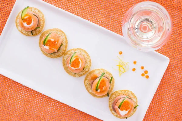 Salmon appetizer and glass of vine, on orange background. View f — Stock Photo, Image