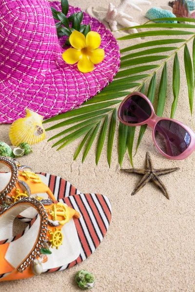 Сандалии, шляпы, солнцезащитные очки и гильзы на песке. Летний пляж — стоковое фото