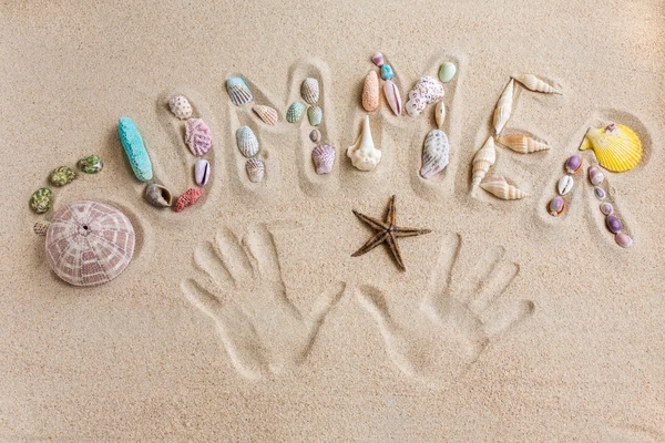 Word summer written by in the sand, with hand prints background — Stock Photo, Image