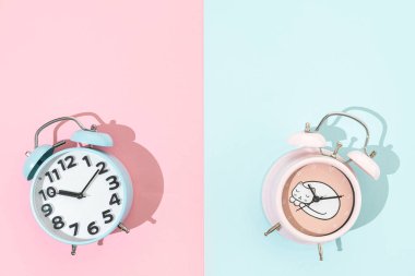 Pembe ve mavi arkaplanda eski moda alarm saatleri, kopyalama alanı olan düz yataklar  