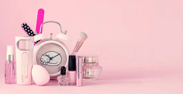 一组专业化妆品和粉红背景的旧时钟 有复制空间 — 图库照片
