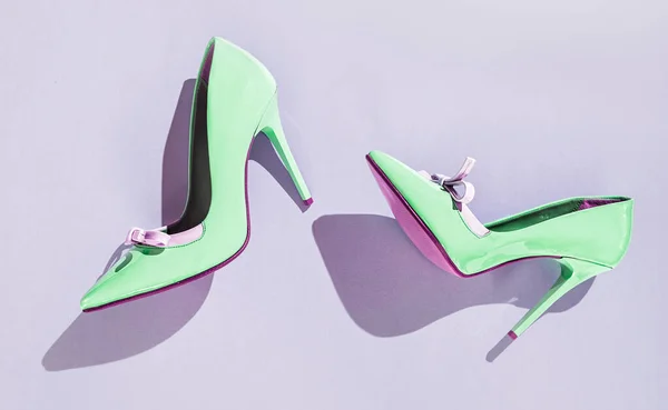 紫の背景に影のある薄緑色の高いヒールの靴のペア フラットラ — ストック写真