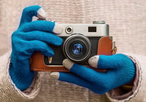 People, photography, technology, leisure and lifestyle. Close up of young hipster woman hands in winter gloves holding retro vintage film camera
