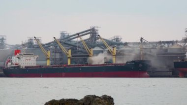 UKRAINE, CHERNOMORSK - 07, 2021: Sukhoi, Karadeniz, Ukrayna 'daki ticari limanın altyapısı, iskelenin yakınındaki bir gemiye çimento yükleme