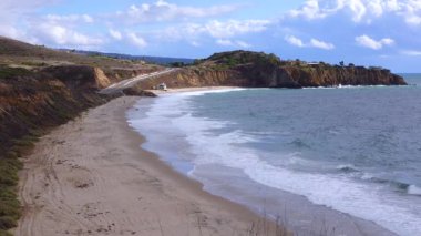 Malibu bölgesindeki Pasifik Okyanusu 'nun kumlu kıyılarında büyük dalgalar kıyıya vuruyor..