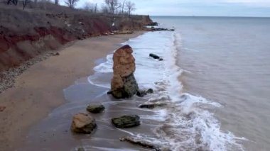 İHA atışı. Karadeniz 'de beyaz deniz dalgaları, Odessa şehri yakınlarındaki sahilde güzel bir kaya, Ukrayna' nın en tepeden görünen manzarası.