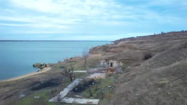 Khadzhibey nehrinin kıyısında yanmış bir balıkçı kulübesi. Kıyıya saçılmış çöpler. Doğayı kirletiyor.