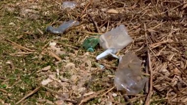 Bir su deposunun kıyısında plastik çöp, şişe ve polietilen, doğanın kirliliği