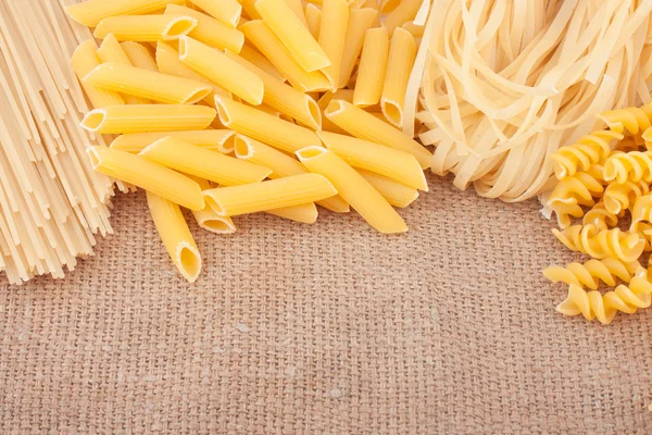 Different types of pasta on burlap — Stock Photo, Image